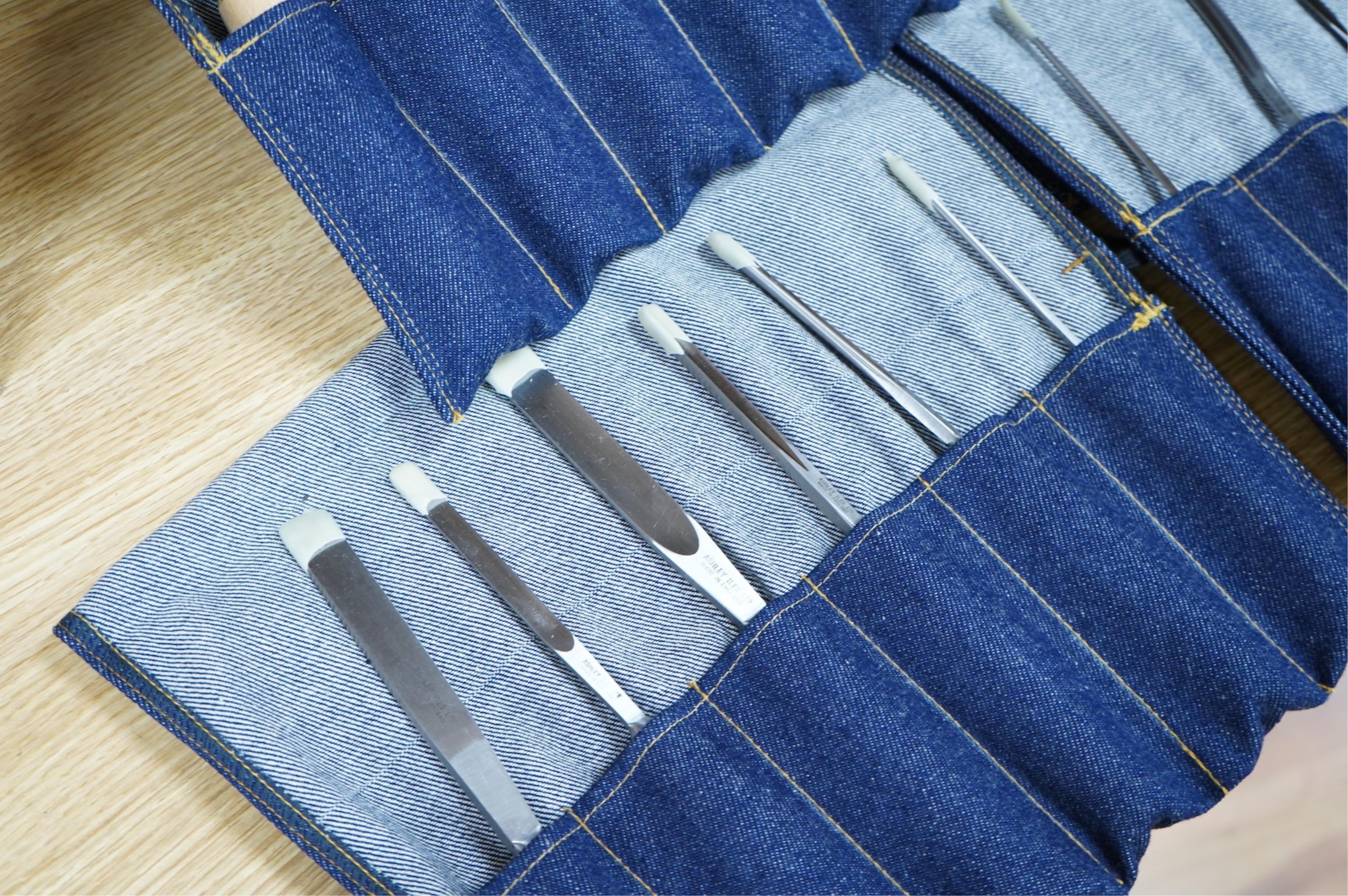 Three sets of Ashley Iles wood carving tools, contained within denim tool rolls; the York Set, the Supplementary Set No.Two, and the Supplementary Set No.Three, each comprising of six chisels (18 chisels in total)